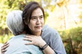 Asian woman pretending to show love to the elderly people by embracing,facial expression,insincere female caregiver thinking about Royalty Free Stock Photo