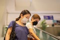 Asian women in protective mask standing on escalator in shopping mall.