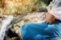 Asian women reading a book sitting on the rock near waterfall in forest background Royalty Free Stock Photo