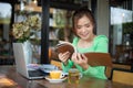 Asian women reading book and smiling and happy Relaxing in a coffee shop after working in a successful office Royalty Free Stock Photo
