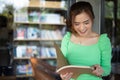 Asian women reading book and smiling and happy Relaxing in a coffee shop after working in a successful office Royalty Free Stock Photo