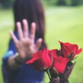 An Asian women rejecting a red rose flower from her boyfriend on Valentine`s day with nature Royalty Free Stock Photo