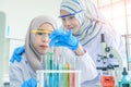 Asian women scientist with test tube making research in clinical laboratory.Science Oil pouring, Formulating the chemical for