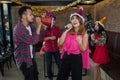 Asian woman singer in santa claus hat with a microphone singing and dancing in Christmas party and friend in restaurant. Royalty Free Stock Photo