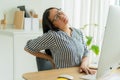 Asian women sitting on chair with hand touch her back suffering having back pain , Asia businesswoman working on computer problem Royalty Free Stock Photo