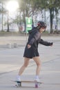 Asian women on skates board outdoors on beautiful summer day. Happy young women play surfskate at park on morning time. Sport