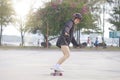 Asian women on skates board outdoors on beautiful summer day. Happy young women play surfskate at park on morning time. Sport