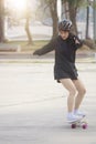 Asian women on skates board outdoors on beautiful summer day. Happy young women play surfskate at park on morning time. Sport