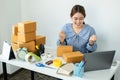 Asian women small business owner looking information order on laptop and raise two arms when job finished