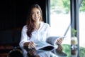 Asian women smiling and reading a book for relaxation at coffee Royalty Free Stock Photo