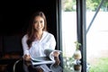 Asian women smiling and reading a book for relaxation at coffee cafe Royalty Free Stock Photo