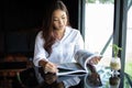 Asian women smiling and reading a book for relaxation at coffee cafe Royalty Free Stock Photo