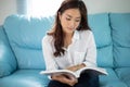 Asian women smiling and reading a book for relaxation at home Royalty Free Stock Photo