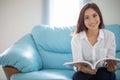 Asian women smiling and reading a book for relaxation at home Royalty Free Stock Photo