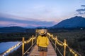 Asian women standing on a wooden bridge, a bridge that stretches in the middle of a meadow, is a natural viewpoint.