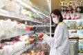 Asian women and surgical mask shopping some food in supermarket, covid-19 crisis Royalty Free Stock Photo