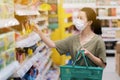 Asian women and surgical mask shopping some food in supermarket, covid-19 crisis Royalty Free Stock Photo