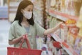 Asian women and surgical mask shopping some food in supermarket, covid-19 crisis Royalty Free Stock Photo