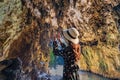 Asian women tourist lifts camera to take a photo inside Tham Lod cave Pai, Maehongson Royalty Free Stock Photo