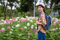 Asian women tourists backpack he is standing posing for a model fashion concept. at spider flower garden. happily during travel Royalty Free Stock Photo