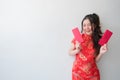 Asian women in traditional Chinese cheongsam dresses and showing red envelopes for chinese new year