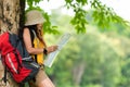 Asian women and traveler and tourism with backpack adventure holding map to find location directions and leisure destination