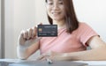 Asian women use a credit card to pay through online purchases, Payment by credit card or online banking, Shopping and mail