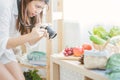 Asian woman using camera Taking pictures to vegetables on table kitchen.