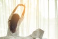 Asian women waking up stretching in bed at home, morning and sunny day Royalty Free Stock Photo