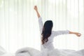Asian women waking up stretching in bed room Royalty Free Stock Photo