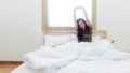 Asian women waking up stretching and raise arms in bed room at home. Royalty Free Stock Photo