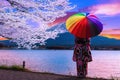 .Asian women wear Japanese kimonos. Holding a rainbow umbrella at Mount Fuji and cherry blossoms at Lake Kawaguchiko in Japan Royalty Free Stock Photo