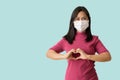 Asian women wear medical face mask shows making heart with her hands