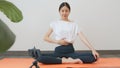 Asian women wearing sportswear and training online course yoga on smartphone in living room at home. wellness concept. Royalty Free Stock Photo