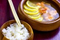 Asian wooden bowl with traditional light spicy thai cuisine rice and tom yam soup with shrimps, seafood and lemon on board Royalty Free Stock Photo
