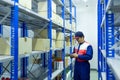 Asian worker on a automotive spare parts warehouse checking products