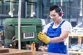 Asian worker in factory on drilling machine