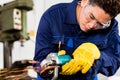 Asian worker grinding metal in manufacturing plant Royalty Free Stock Photo