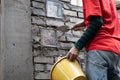 Asian worker installing glass block onto brick wall with mortar