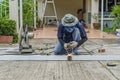 asian worker with machine cutting metal and welded steel to create a roof, local labor construction concept