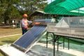 The Asian worker in uniform and helmet checks concentrating Solar Power with Flat Plat collector and Evacuum Tube Collector.