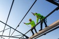 Asian worker wear safety height equipment to build a steel roof structure in the construction site