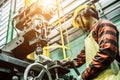 Asian worker wearing the goggle, helmet, ear muff equipment in production plant Royalty Free Stock Photo