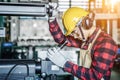 Asian worker wering the goggle, helmet, ear muff equipment in production plant