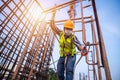 Asian worker working at height equipment constructive at construction site. Fall arrestor device for worker with hooks for safety Royalty Free Stock Photo