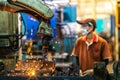 Asian worker working in old chinese factory in robot auto welding machine section