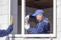 Asian workers install windows to the house Royalty Free Stock Photo