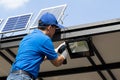 Asian workers technicians man installing solar photovoltaic panels for LED lamps on the roof of the house.