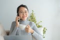 Asian working woman on her face wear glasses , smile , talk on telephone .Young business woman is drinking coffee and looking Royalty Free Stock Photo