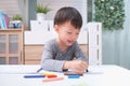 Asian 3 - 4 years old toddler boy child coloring with crayons at home, improve focus in child concept